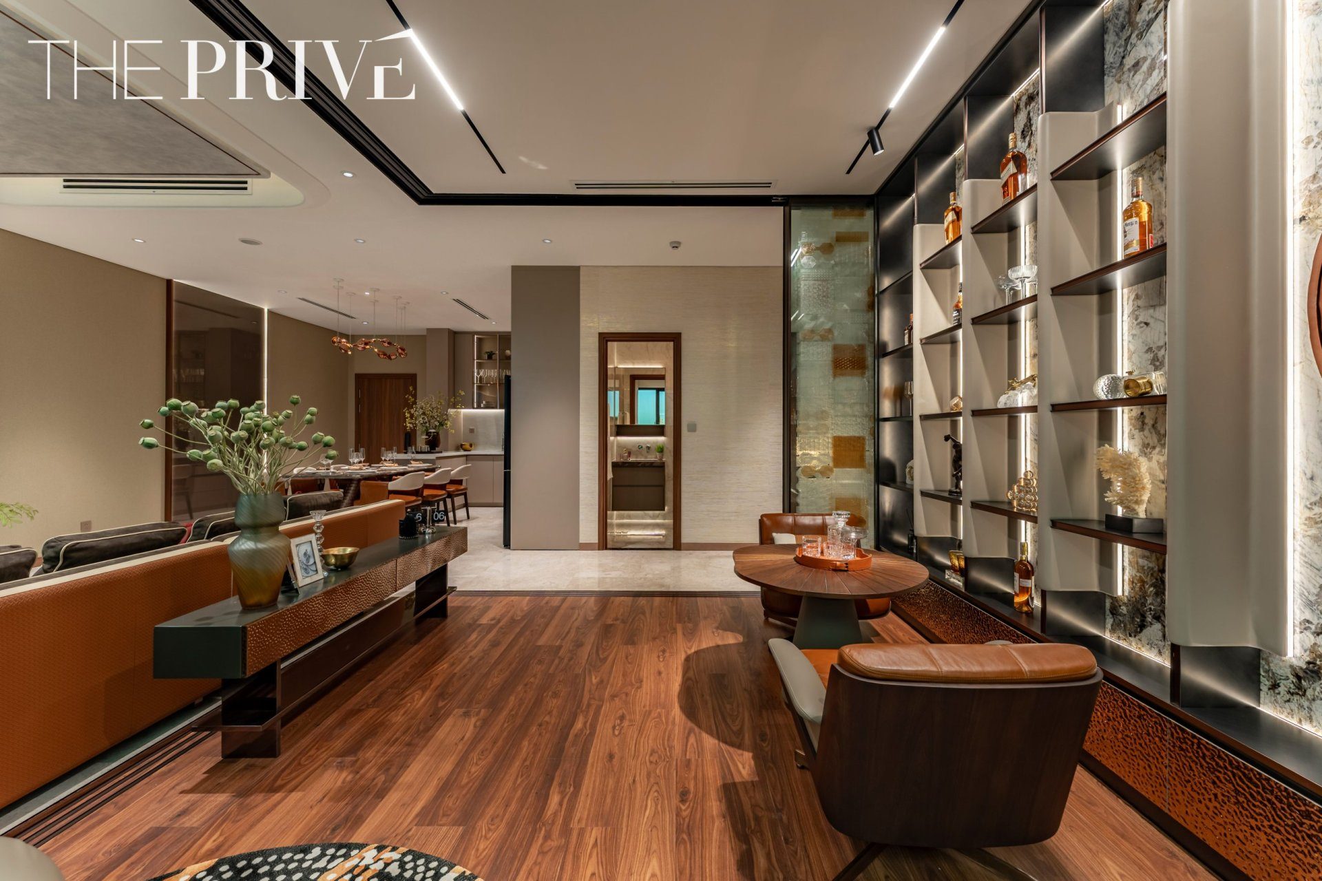 Phòng khách căn hộ mẫu 3PN The Privé lót sàn gỗ, kệ trưng bày âm tường